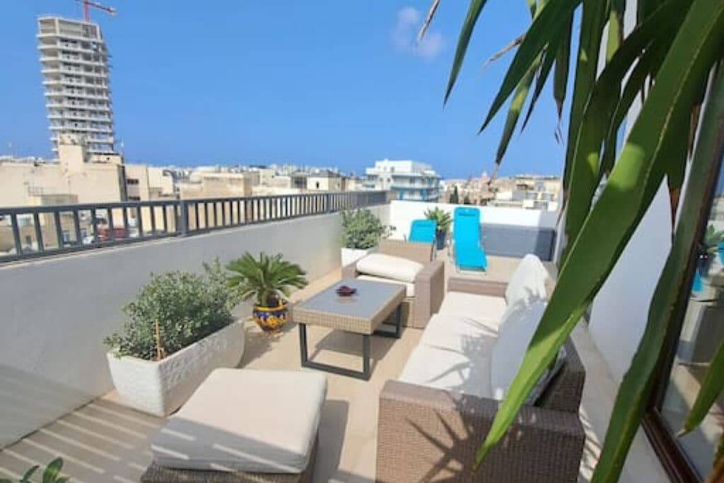 Sunny rooftop terrace with lounge seating at a Mink Homes serviced apartment in Malta — book direct