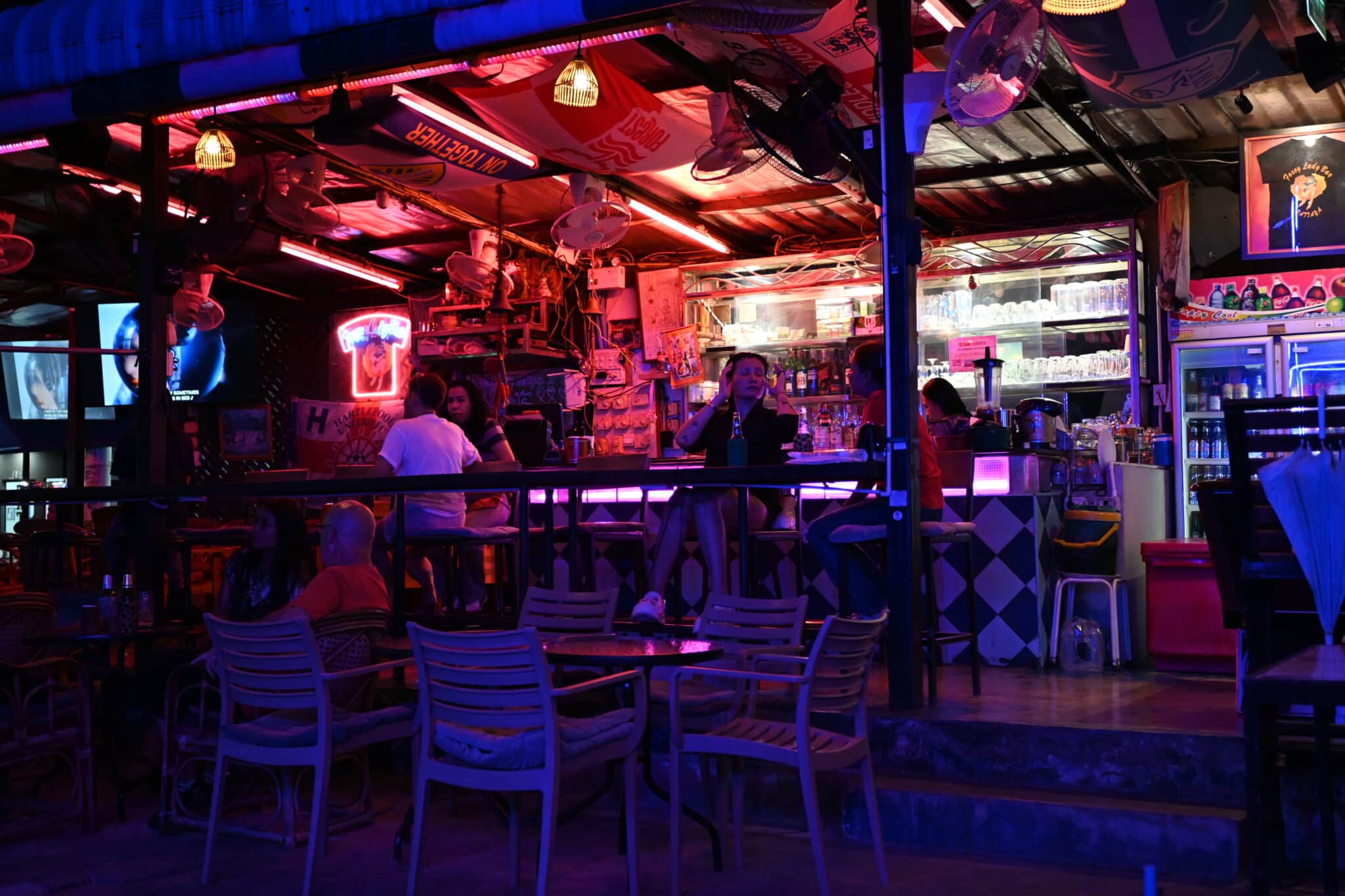 Neon-lit cocktail bar interior with warm evening atmosphere, similar to Hugo's Lounge in Paceville