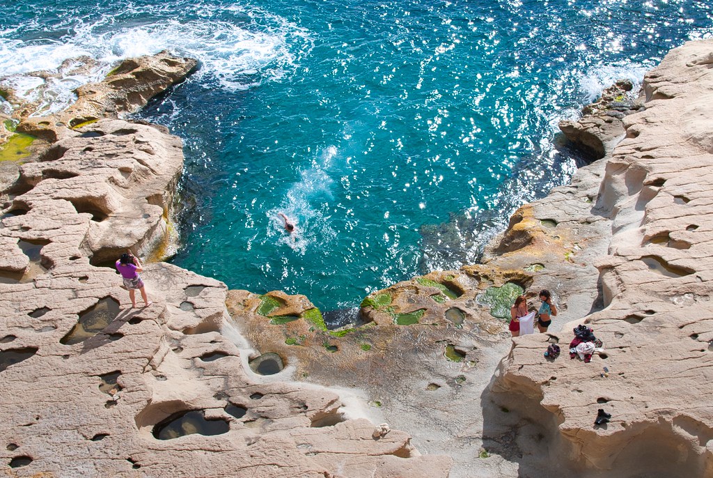 Clear turquoise water and limestone cliffs at St Peter's Pool near Marsaxlokk, Malta